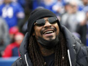 Marshawn Lynch stands on the field before an NFL football game between the Buffalo Bills and the Indianapolis Colts in Orchard Park, N.Y., Nov. 21, 2021.