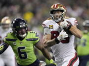 San Francisco 49ers tight end George Kittle, right, runs toward the end zone to score past Seattle Seahawks safety Quandre Diggs (6) during the first half of an NFL football game in Seattle, Thursday, Dec. 15, 2022.
