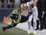 San Francisco 49ers running back Christian McCaffrey, right, runs against Seattle Seahawks linebacker Boye Mafe (53) during the first half of an NFL football game in Seattle, Thursday, Dec. 15, 2022.