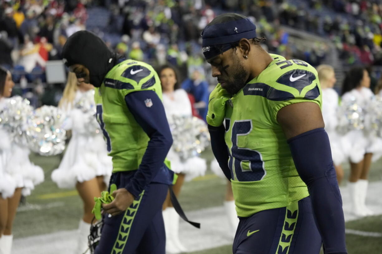 Seattle Seahawks cornerback Coby Bryant, left, and linebacker Jordyn Brooks walk off the field after an NFL football game against the San Francisco 49ers in Seattle, Thursday, Dec. 15, 2022.