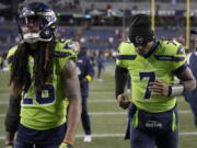 Seattle Seahawks safety Ryan Neal, left, and quarterback Geno Smith walk off the field after an NFL football game against the San Francisco 49ers in Seattle, Thursday, Dec. 15, 2022.