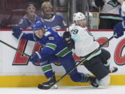 Vancouver Canucks' Curtis Lazar, left, and Seattle Kraken's Vince Dunn collide during the first period of an NHL hockey game Thursday, Dec. 22, 2022, in Vancouver, British Columbia.