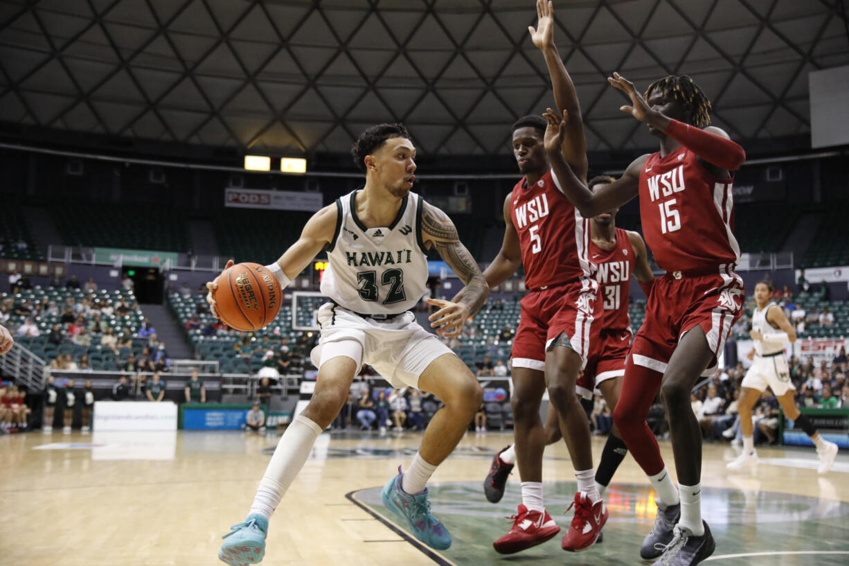 Hawaii guard Samuta Avea (32) tries to get past Washington State guard TJ Bamba (5) and center Adrame Diongue (15) during the second half of an NCAA college basketball game, Friday, Dec. 23, 2022, in Honolulu.