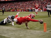 Kansas City Chiefs quarterback Patrick Mahomes (15) dives for the end zone pylon to score a touchdown as Seattle Seahawks linebacker Jordyn Brooks (56) defends during the second half of an NFL football game Saturday, Dec. 24, 2022, in Kansas City, Mo.