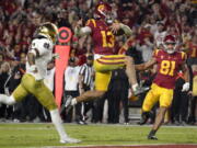 FILE - Southern California quarterback Caleb Williams jumps in for a touchdown as Notre Dame safety Xavier Watts, left, defends and Southern California wide receiver Kyle Ford watches during the second half of an NCAA college football game Saturday, Nov. 26, 2022, in Los Angeles. Southern California quarterback Caleb Williams was named the AP Player of the Year in college football, Thursday, Dec. 8, 2022. (AP Photo/Mark J.