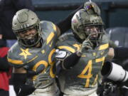 Army defensive back Noah Short (47) celebrates blocking a punt return by Navy punter Riley Riethman for a touchdown in the second quarter of an NCAA college football game in Philadelphia, Saturday, Dec. 10, 2022. At left is fellow defensive back Donavon Platt.