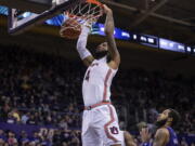 RETRANSMISSION TO CORRECT DAY AND DATE - Auburn forward Johni Broome dunks over Washington guard PJ Fuller II during the first half of an NCAA college basketball game, Wednesday, Dec. 21, 2022, in Seattle.