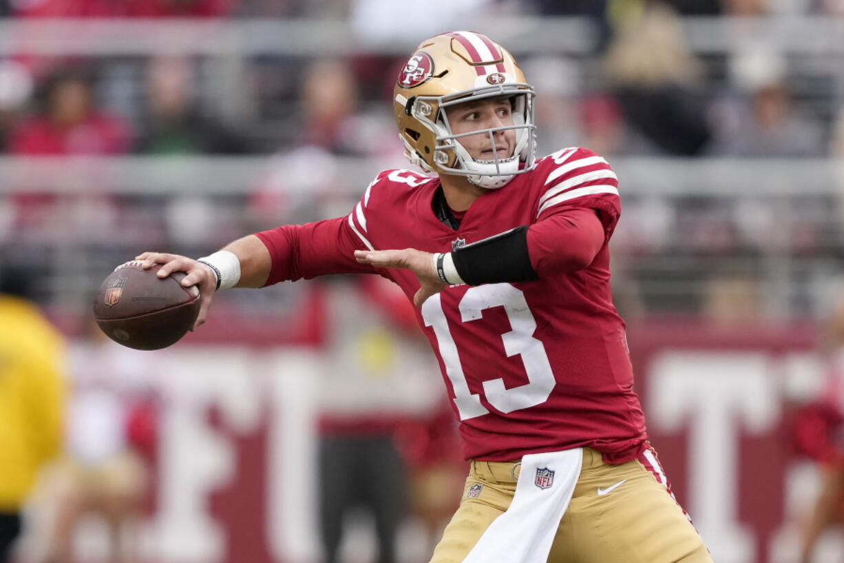 San Francisco 49ers quarterback Brock Purdy (13) throws a touchdown pass to running back Christian McCaffrey during the first half of an NFL football game against the Tampa Bay Buccaneers in Santa Clara, Calif., Sunday, Dec. 11, 2022.