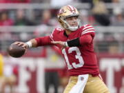 San Francisco 49ers quarterback Brock Purdy (13) throws a touchdown pass to running back Christian McCaffrey during the first half of an NFL football game against the Tampa Bay Buccaneers in Santa Clara, Calif., Sunday, Dec. 11, 2022.