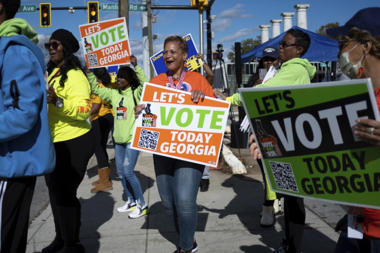 FILE - People gather during a get out the vote rally Nov. 27, 2022, in Atlanta, during early voting for the Senate runoff election. Voters in Georgia appear to have navigated the strict election law passed last year by Republicans with little difficulty. But voting rights groups say it's too soon to assess the full impact of the law, since it's not certain how many voters may have been dissuaded from casting a ballot.