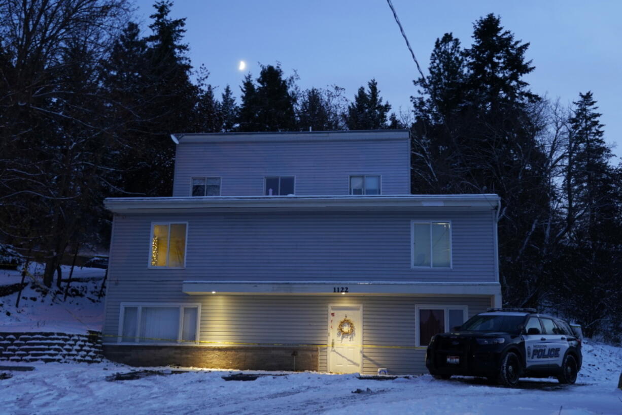 FILE - The moon rises on Nov. 29, 2022, as a Moscow police officer stands guard in his vehicle at the home where four University of Idaho students were found dead on Nov. 13, 2022 in Moscow, Idaho. It's been nearly three weeks since four University of Idaho students were found stabbed to death in a home near campus, but there are still more questions than answers surrounding the investigation. (AP Photo/Ted S.