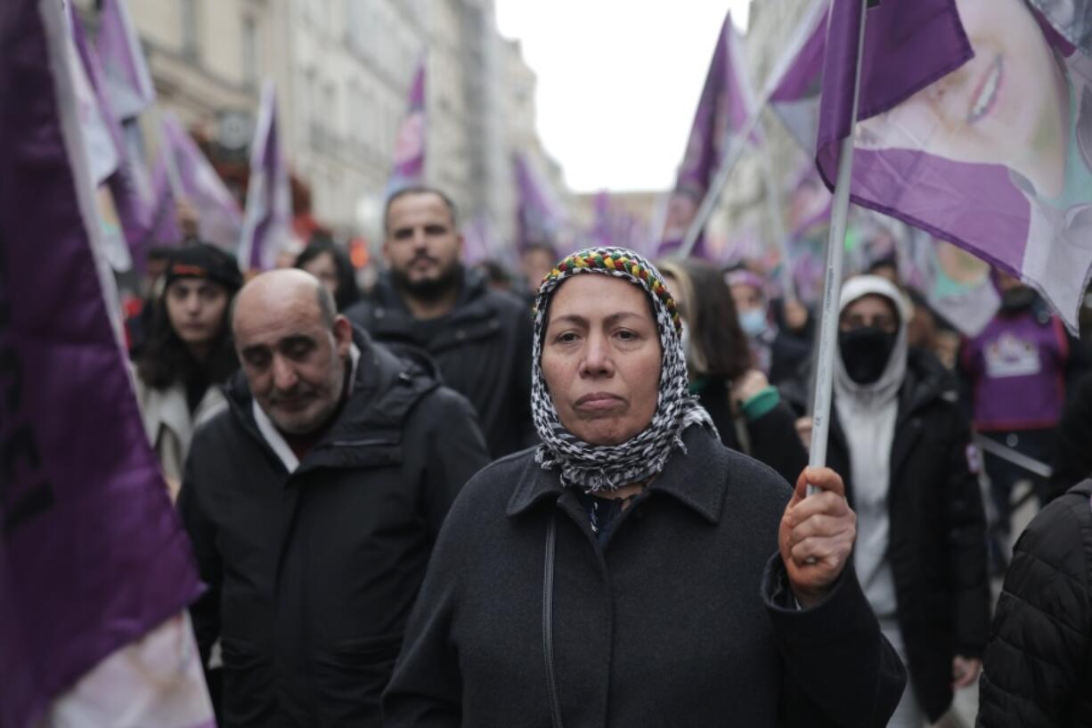 Kurdish activists hold flags during a march to honor three women Kurdish activists who were shot dead in 2013, Monday, Dec. 26, 2022 in Paris. A 69-year-old Frenchman is facing preliminary charges of racially motivated murder, attempted murder and weapons violations over last Friday's shooting, prosecutors said. The shooting shocked and infuriated the Kurdish community in France.