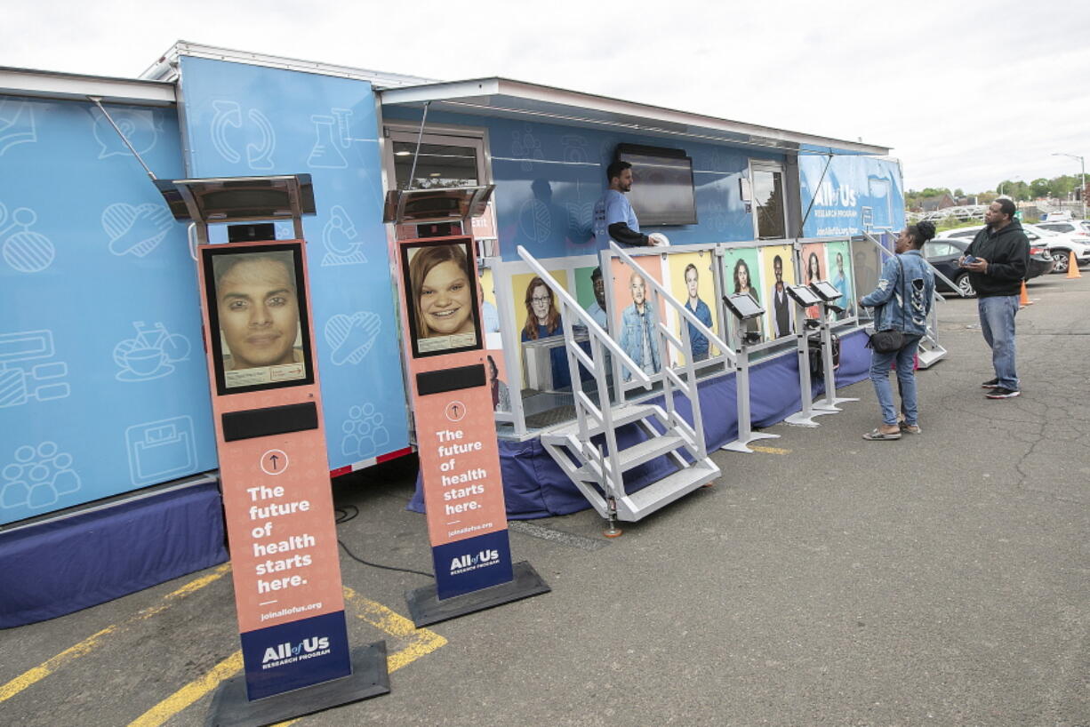 FILE - People stand by the All of Us Mobile Education and Enrollment Center at the Community Health Center on State Street in Meriden, Conn., May 13, 2019. Thousands of Americans who shared their DNA for science are about to learn something in return: if they harbor some problematic genes. It's part of a massive National Institutes of Health project to unravel how people's genetics, environments and habits interact to mold their health.