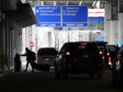 An airline passenger walks between ride share vehicles after arriving at Chicago's Midway Airport just days before a major winter storm Tuesday, Dec. 20, 2022, in Chicago.