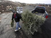 George Highhouse of Scranton, Pa., brings his Christmas tree and a wreath to Lackawanna County Recycling on Jan. 2, 2019, in Dunmore, Pa.