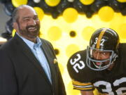 FILE - Former Pittsburgh Steelers running back Franco Harris stands next a statute of himself on Sept. 12, 2019, at Pittsburgh International Airport near Pittsburgh.