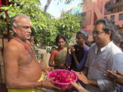 Arjun Viswanathan places his hands on a basket of flowers to be offered to the Hindu deity Ganesh at the Sri Lakshmi Visa Ganapathy Temple on Nov. 28 in Chennai, a city on the southern coast of India.