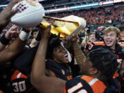 Oregon State players celebrate with the trophy after defeating Florida in the Las Vegas Bowl NCAA college football game Saturday, Dec. 17, 2022, in Las Vegas.