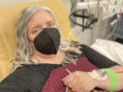 This photo provided by Amy Watson of Portland, Ore., shows her during an iron infusion in December 2022. Watson, approaching 50, says she has "never had any kind of recovery" from COVID-19. She has had severe migraines, plus digestive, nerve and foot problems. Recently she developed severe anemia.