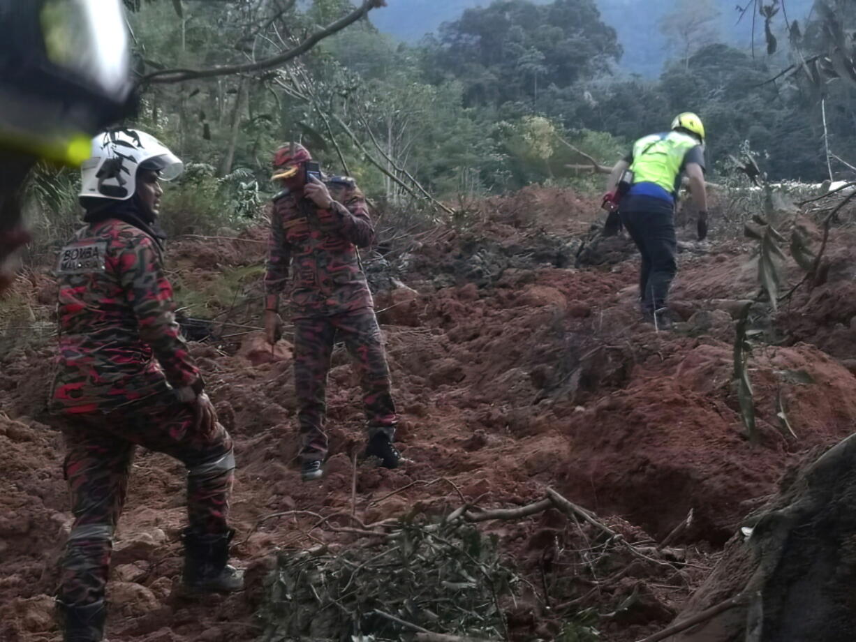 In this photo released by Korporat JBPM, rescuers work during a rescue and evacuation operation following a landslide at a campsite in Batang Kali, Selangor state, on the outskirts of Kuala Lumpur, Malaysia, Dec. 16, 2022.