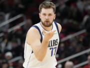 Dallas Mavericks guard Luka Doncic reacts after making a 3-point basket during the second half of an NBA basketball game against the Houston Rockets, Friday, Dec. 23, 2022, in Houston.