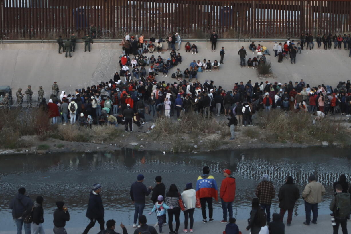 Migrants gather at a crossing into El Paso, Texas, as seen from Ciudad Juarez, Mexico, Tuesday, Dec. 20, 2022. Tensions remained high at the U.S-Mexico border Tuesday amid uncertainty over the future of restrictions on asylum-seekers, with the Biden administration asking the Supreme Court not to lift the limits before Christmas.