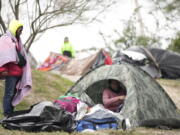 FILE - Migrants from Venezuela prepare for relocation to a refugee shelter in Matamoros, Mexico, Dec. 23, 2022. The Supreme Court is keeping pandemic-era limits on people seeking asylum in place indefinitely, dashing hopes of immigration advocates who had been anticipating their end this week. The restrictions, often referred to as Title 42, were put in place under then-President Donald Trump at the beginning of the pandemic to curb the spread of COVID-19.