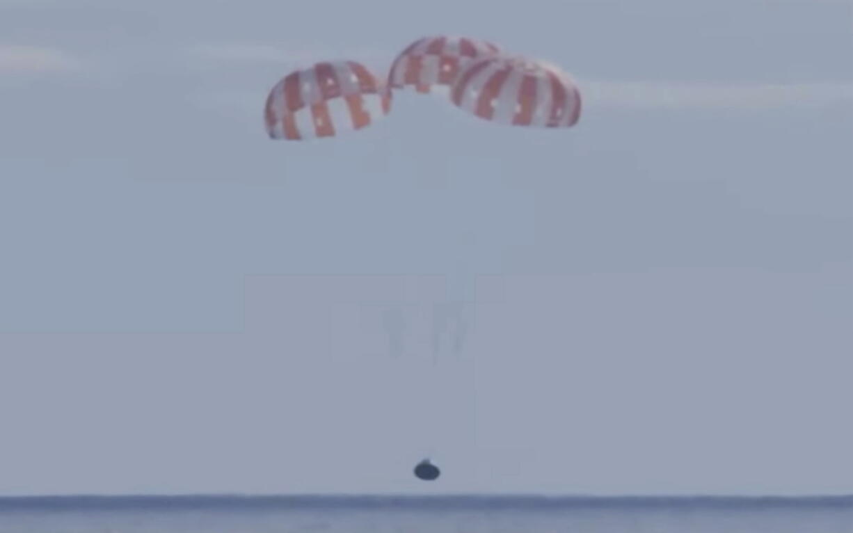 This photo provided by NASA shows the Orion capsule coming back from the moon. The capsule made a blisteringly fast return Sunday, Dec. 11, 2022, parachuting into the Pacific off Mexico to conclude a dramatic 25-day test flight. The mission should clear the way for astronauts on the program's next lunar flyby, set for 2024.