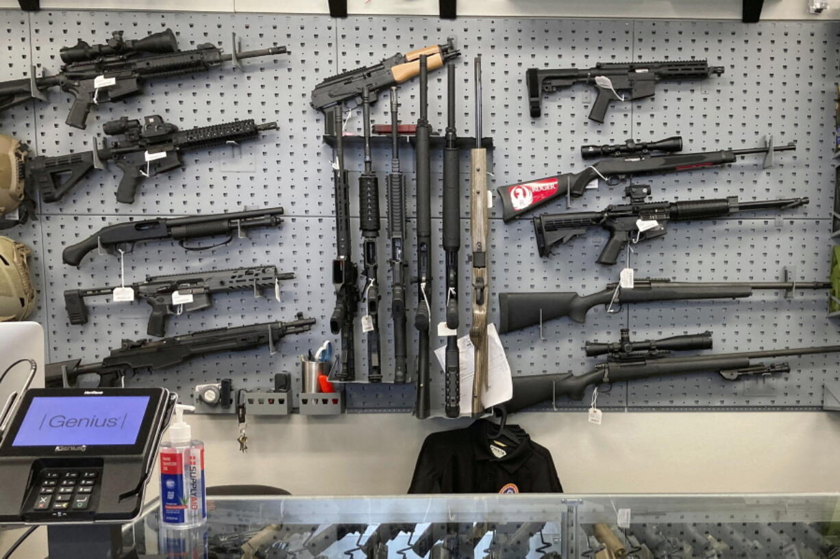 FILE - Firearms are displayed at a gun shop in Salem, Ore., on Feb. 19, 2021. A federal judge in Portland, Ore., ruled Tuesday, Dec. 6, 2022, that a new voter-passed ban on high-capacity gun magazines can go into effect Thursday, Dec. 8, but placed a 30-day hold on a permit-to-purchase requirement after local and state law enforcement agencies said they could not have a permitting system ready in time.