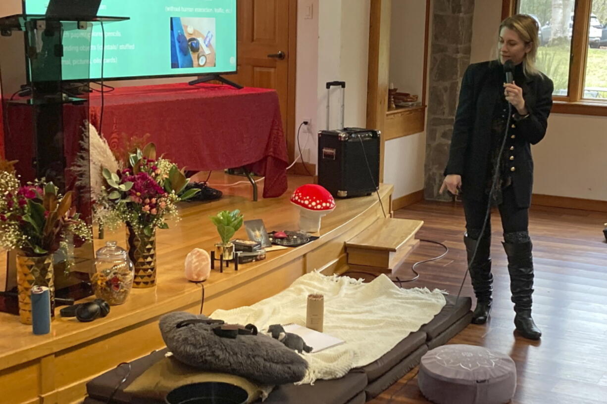 Gina Gratza, a trainer for students learning how to become psilocybin facilitators, shows the items that she would have at a dosing session, including mats, a pillow, a purge bucket, a sketch pad with colored pencils and tissues during a class near Damascus, Ore., on Dec. 2, 2022.