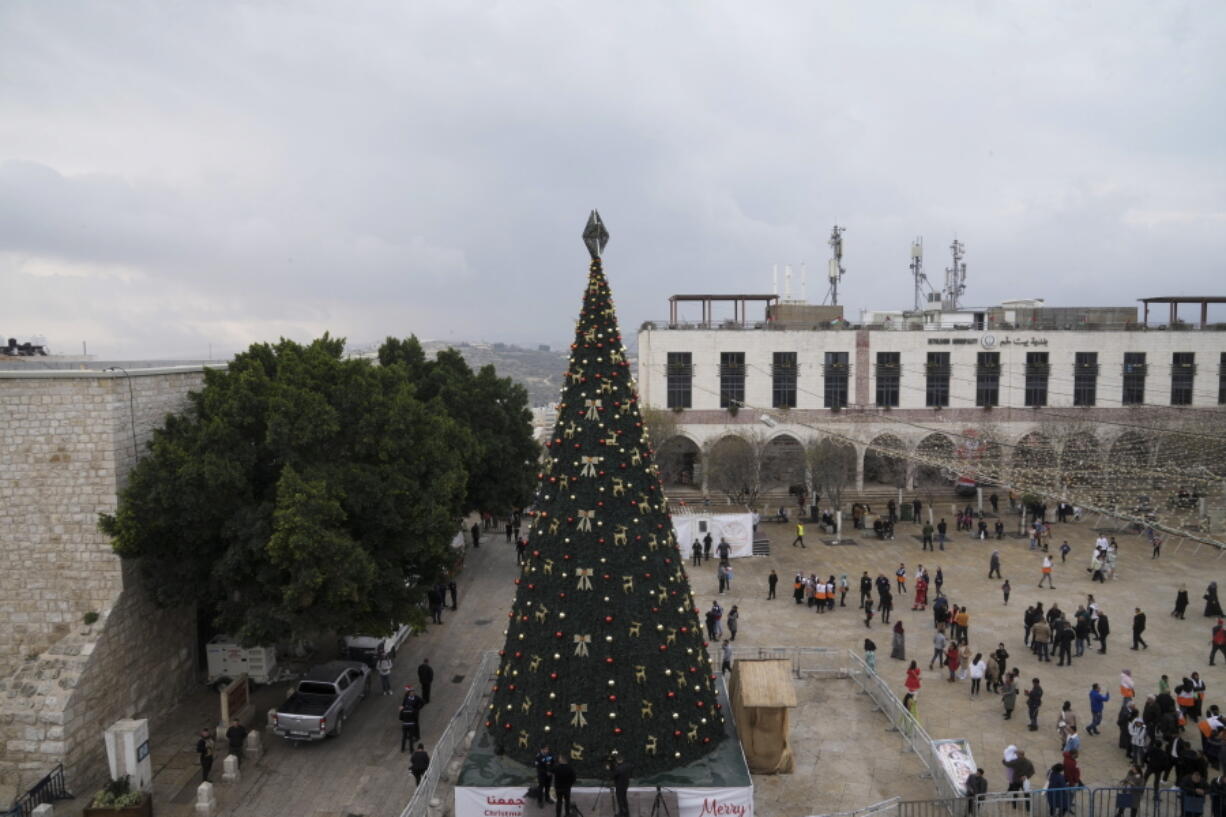 People gather in Manger Square, adjacent to the Church of the Nativity, traditionally believed to be the birthplace of Jesus Christ, in the West Bank town of Bethlehem, Saturday, Dec. 24, 2022.