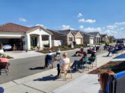 Neighbors of Lisa and Larry Neula watching them perform a Hawaiian dance in their driveway in Sacramento, Calif., in March 2022. The two began their driveway performances during lockdown and have kept them up.