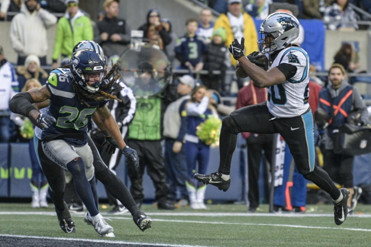 Carolina Panthers running back Raheem Blackshear (20) leaps into the end zone for a touchdown against Seattle Seahawks safety Ryan Neal (26) during the second half of an NFL football game, Sunday, Dec. 11, 2022, in Seattle.