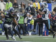 Carolina Panthers running back Raheem Blackshear (20) leaps into the end zone for a touchdown against Seattle Seahawks safety Ryan Neal (26) during the second half of an NFL football game, Sunday, Dec. 11, 2022, in Seattle.