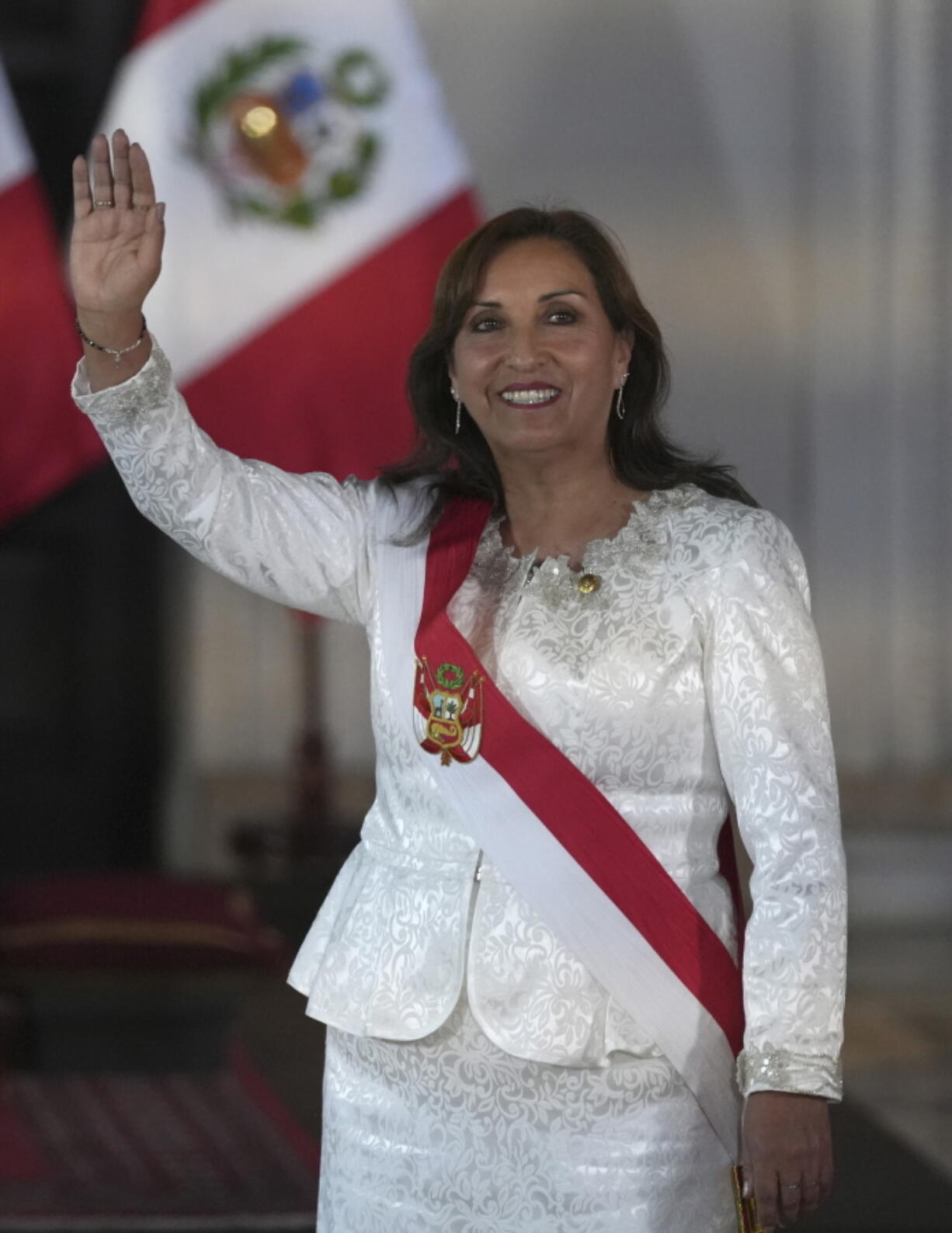 Peru's President Dina Boluarte waves as she arrives to swear in her cabinet members at the government palace in Lima, Peru, Saturday, Dec. 10, 2022.