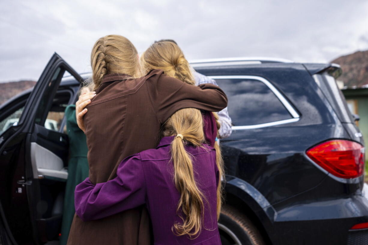 FILE - Three girls embrace before they are removed from the home of Samuel Bateman, following his arrest in Colorado City, Ariz., on Wednesday, Sept. 14, 2022.  Federal documents released Friday, Dec. 2 show that Bateman, the leader of a small polygamous group near the Arizona-Utah border, had taken at least 20 wives, most of whom were minors, and punished followers who did not treat him as a prophet.