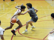 R.A. Long's Cavin Holden drives on Reynolds' Tyler Sanamane (4) at the Fort Vancouver Holiday Classic on Wednesday, Dec. 28, 2022.