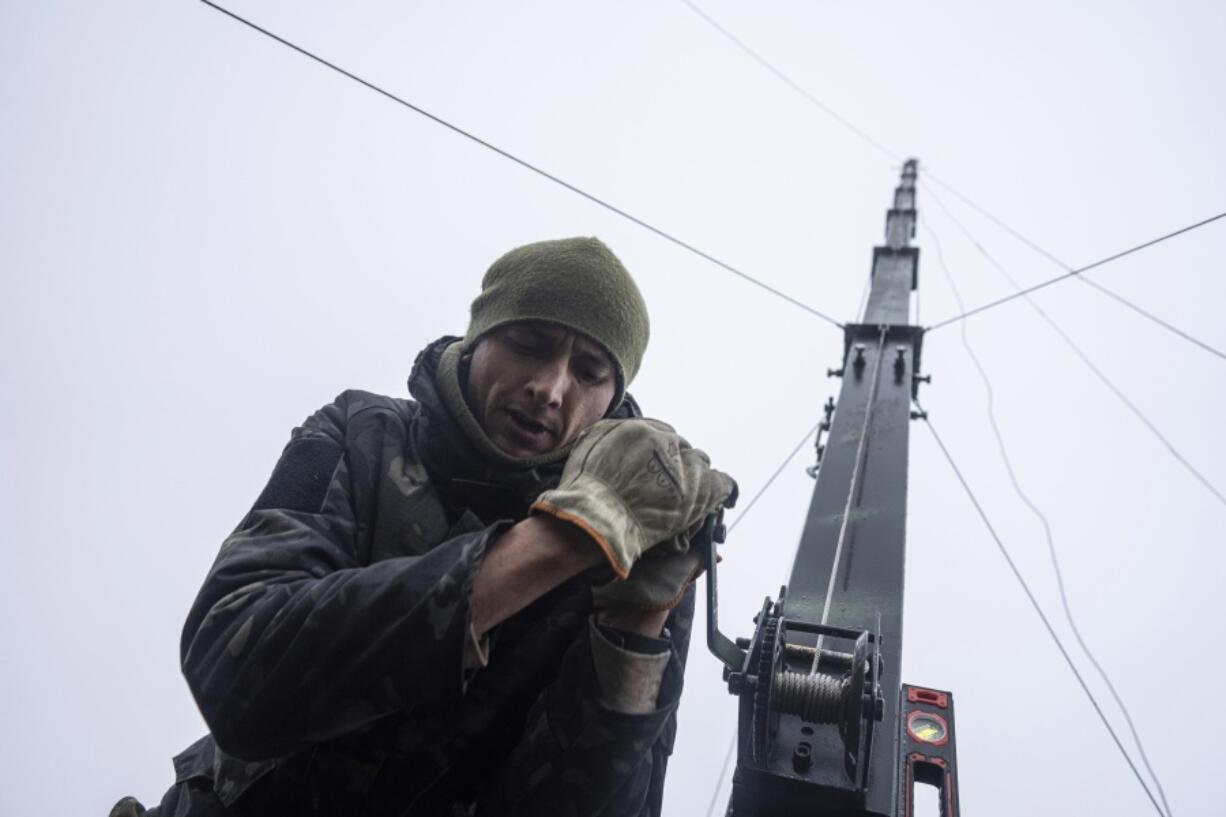 Ukrainian servicemen from 127 brigade prepare a telescopic tower with a remote camera installed on a Soviet car "Volga" that was recast to observe and correct fire on the front line near Kharkiv, Ukraine, Sunday, Dec. 25, 2022.