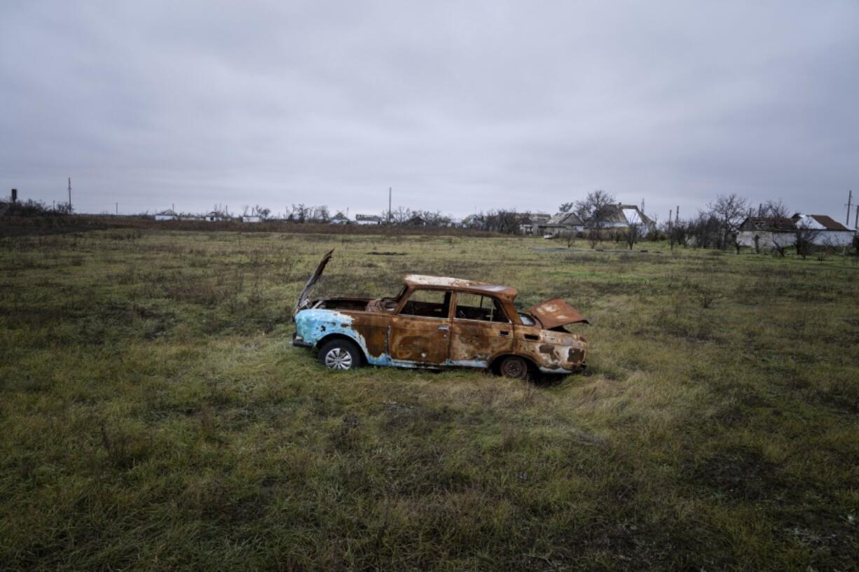 A car destroyed by Russian shelling sits in a field in Posad-Pokrovske village, in the Kherson region, Ukraine, Friday, Dec. 2, 2022.