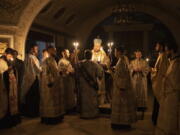 Metropolitan Oleksandr delivers a religious service with clerics inside the Transfiguration of Jesus Orthodox Cathedral during blackout caused by recent Russian rocket attacks, in Kyiv, Ukraine, Saturday, Dec. 3, 2022. A top Orthodox priest in Ukraine's capital says he supports the efforts of President Volodymyr Zelenskyy's government and counter-intelligence agency to end Russian spying and meddling in Ukrainian politics through a Moscow-affiliated church.