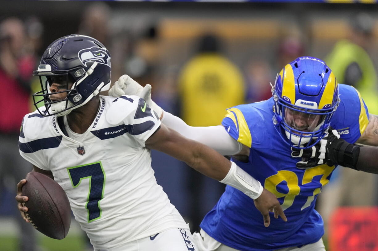 Los Angeles Rams defensive tackle Michael Hoecht (97) sacks Seattle Seahawks quarterback Geno Smith (7) during the first half of an NFL football game Sunday, Dec. 4, 2022, in Inglewood, Calif. (AP Photo/Mark J.