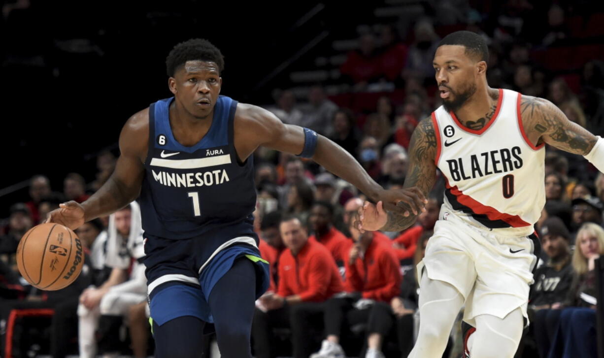 Minnesota Timberwolves guard Anthony Edwards, left, brings the ball up the court on Portland Trail Blazers guard Damian Lillard, right, during the first half of an NBA basketball game in Portland, Ore., Monday, Dec. 12, 2022.