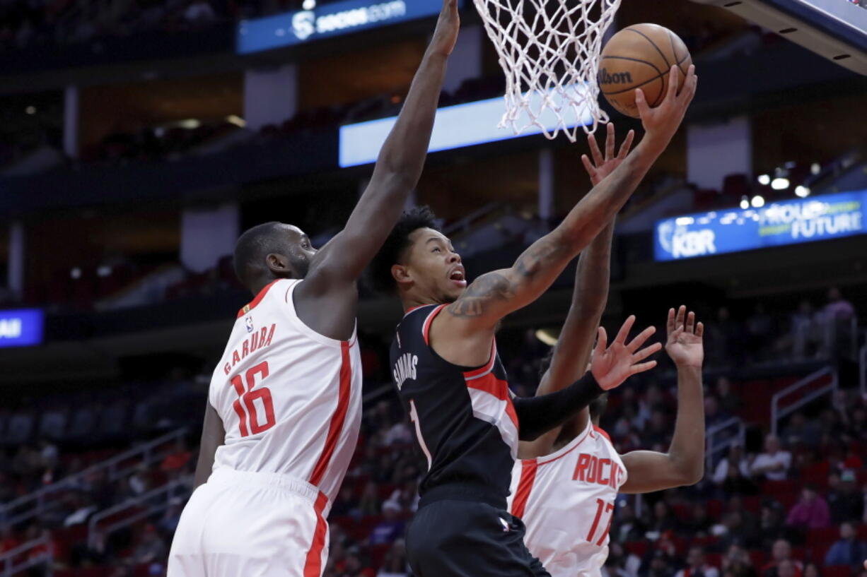 Portland Trail Blazers guard Anfernee Simons (1) lays up a shot between Houston Rockets forwards Usman Garuba (16) and Tari Eason (17) during the first half of an NBA basketball game Saturday, Dec. 17, 2022, in Houston.