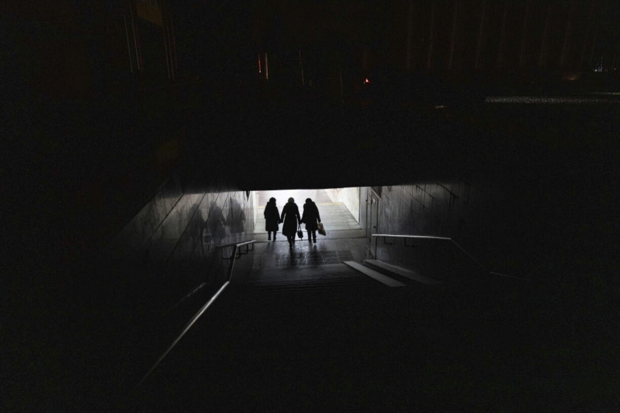 Women walk down to the metro at the city center in Kharkiv, Ukraine, Wednesday, Dec. 21, 2022.