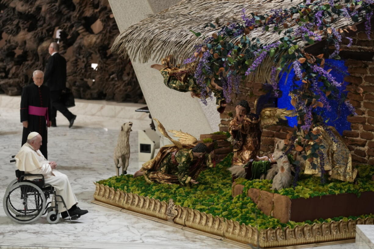 Pope Francis looks at a nativity scene as he leaves after his weekly general audience in the Paul VI Hall, at the Vatican, Wednesday, Dec. 21, 2022.