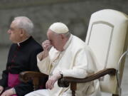 Pope Francis, right, sits next to Monsignor Leonardo Sapienza, left, as they attend the weekly general audience in the Paul VI Hall at the Vatican, Wednesday, Dec. 28, 2022.