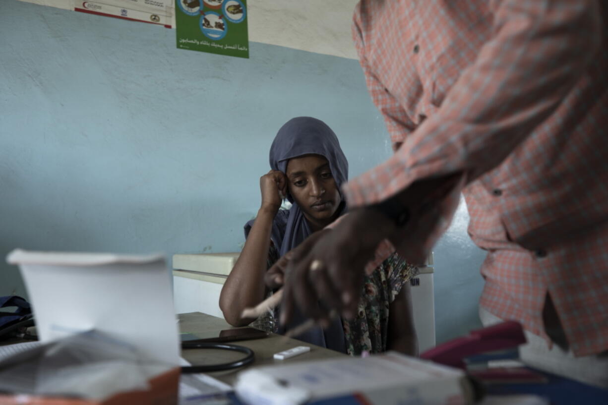 FILE - Surgeon and doctor-turned-refugee, Dr. Tewodros Tefera, prepares a malaria test for 23-year-old Tigrayan refugee Hareg from Mekele, Ethiopia, at the Sudanese Red Crescent clinic in Hamdayet, eastern Sudan, near the border with Ethiopia, on March 17, 2021. The coronavirus pandemic interrupted efforts to control malaria, resulting in 63,000 more deaths and 13 million more infections. That's according to a World Health Organization report released Thursday Dec. 8, 2022.