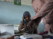 FILE - Surgeon and doctor-turned-refugee, Dr. Tewodros Tefera, prepares a malaria test for 23-year-old Tigrayan refugee Hareg from Mekele, Ethiopia, at the Sudanese Red Crescent clinic in Hamdayet, eastern Sudan, near the border with Ethiopia, on March 17, 2021. The coronavirus pandemic interrupted efforts to control malaria, resulting in 63,000 more deaths and 13 million more infections. That's according to a World Health Organization report released Thursday Dec. 8, 2022.