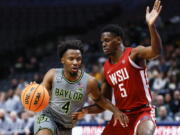 Baylor guard LJ Cryer (4) battles Washington State guard TJ Bamba (5) for space during the first half of an NCAA college basketball game on Sunday, Dec. 18, 2022, in Dallas.