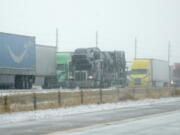 Tractor trailers are stacked up on the shoulder along the eastbound lanes of Interstate 70 near East Airpark Road, Tuesday, Dec. 13, 2022, in Aurora, Colo. A massive winter storm has closed roads throughout northeast Colorado.